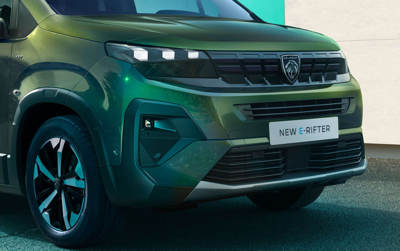 Чоловік стоїть перед Peugeot Rifter, жінка біля водійських дверей